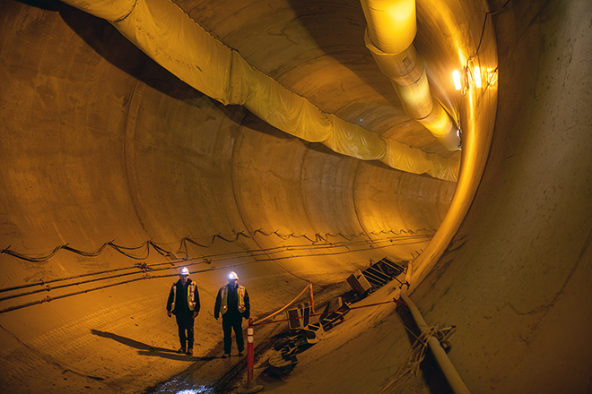 Workers walk through a segment of one of the diversion tunnels, recently lined with concrete.