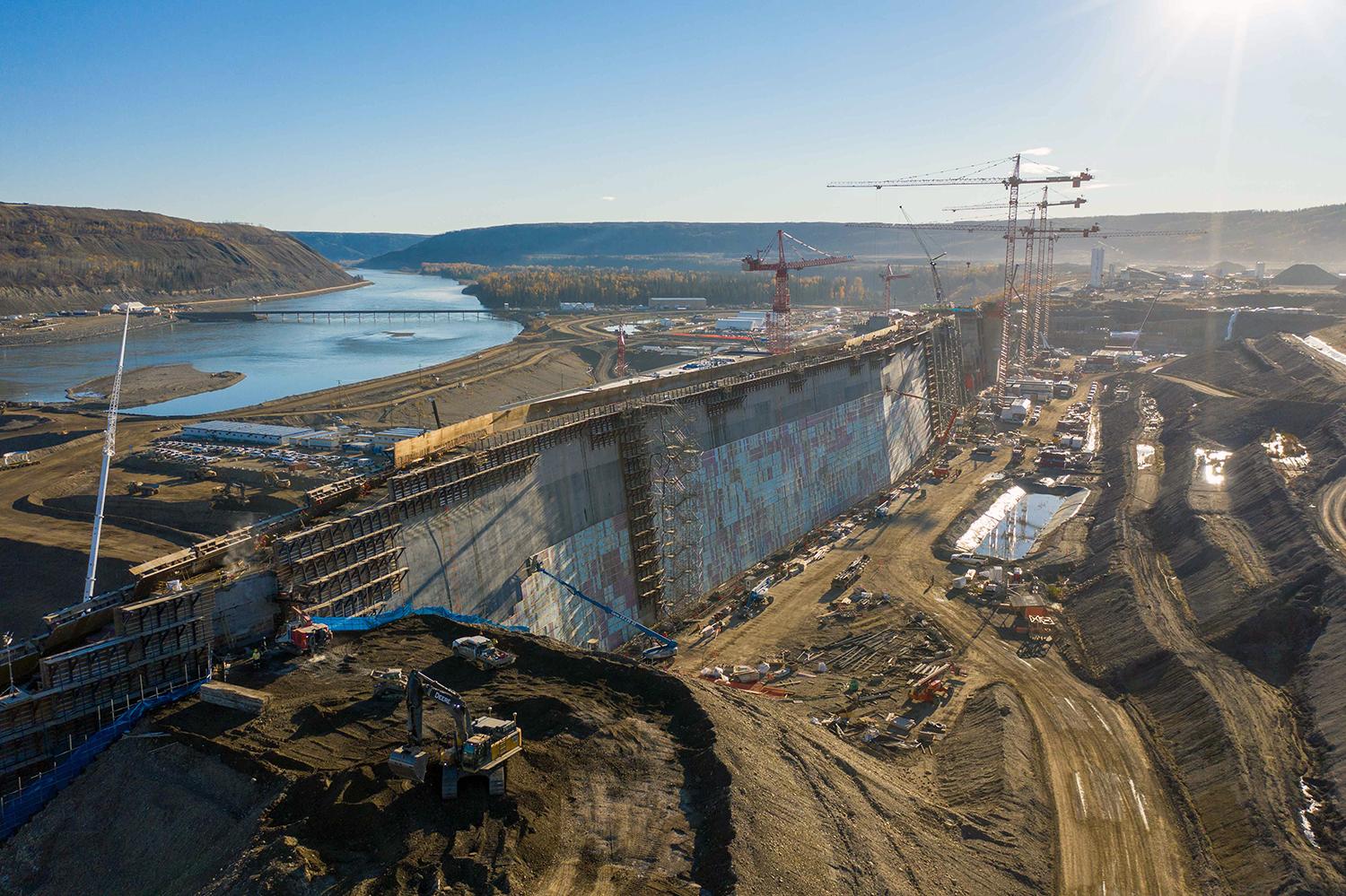 Roller-compacted concrete ramps are removed from the dam core buttress and insulation is installed on the upstream side of the buttress. | October 2021