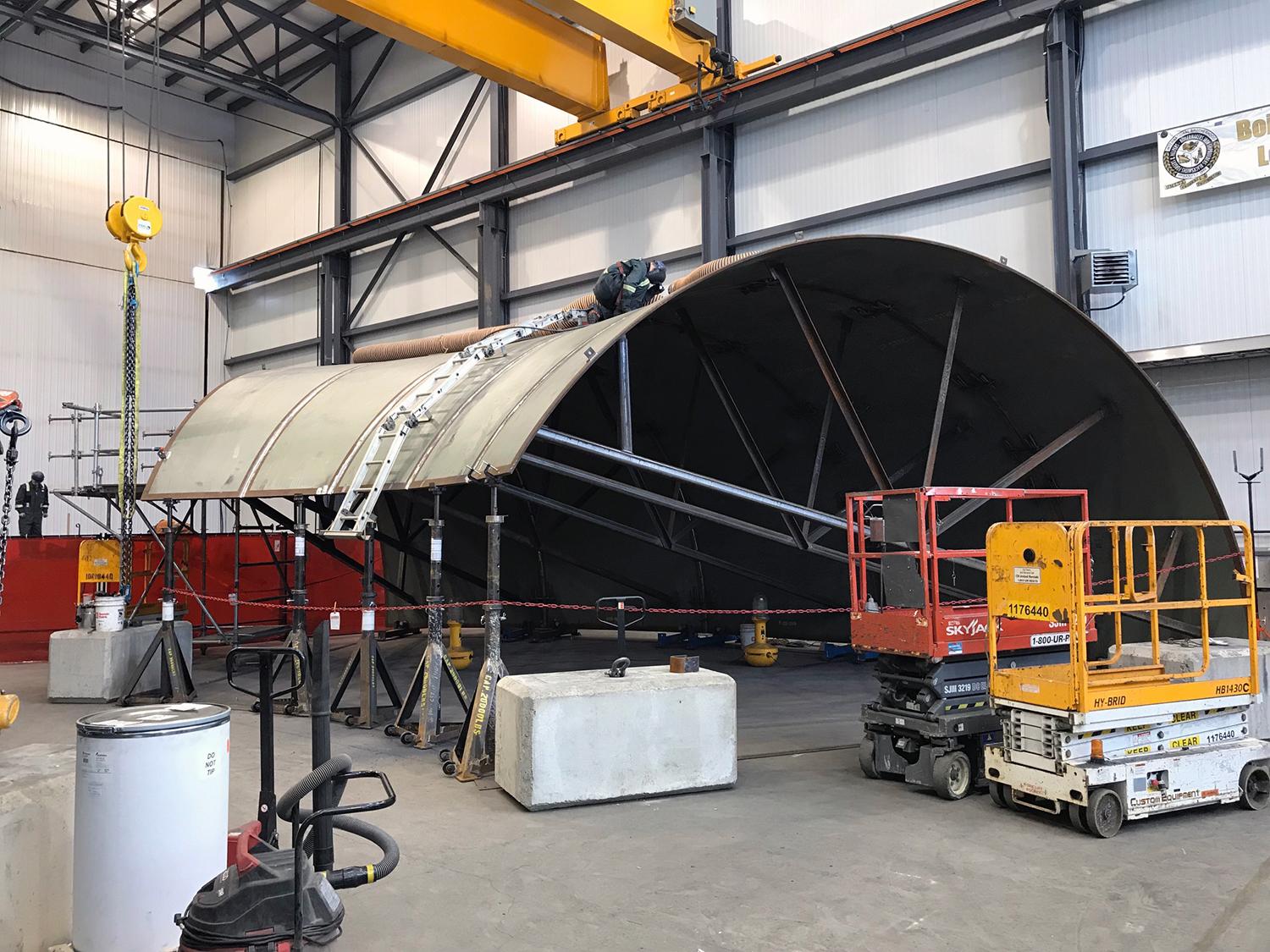 The bottom section of a spiral case being welded by a robot welder by LAR at the Voith shop on site. | February 2019