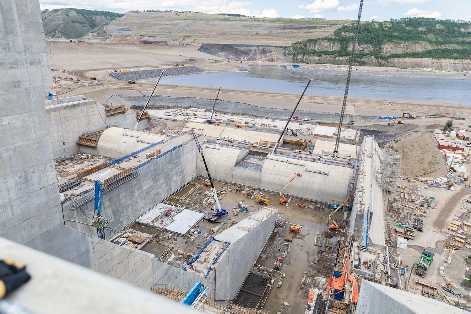 North-facing over the stilling basin of the east spillway Looking down into the east stilling basin. Forming and placing concrete for the walls, the concrete slab, and completing the weir structure. | May 2023