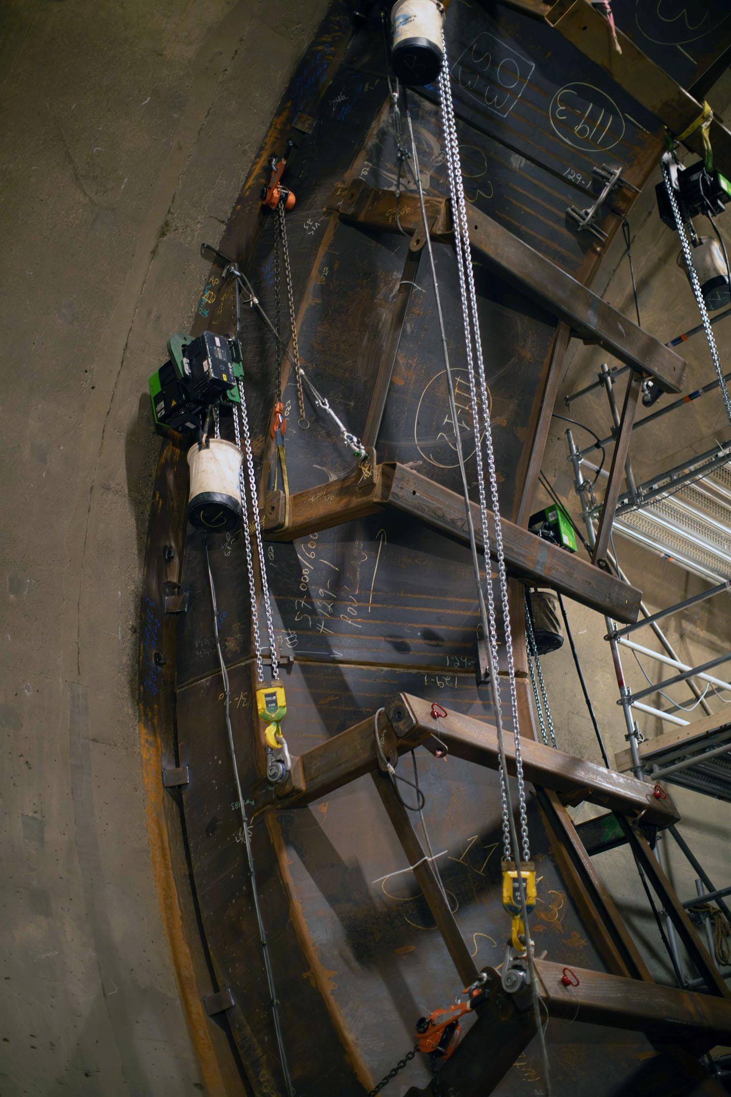 Segments of the ring are hoisted into position and welded. Crews will complete the welds to the embedded steel in the tunnel walls.