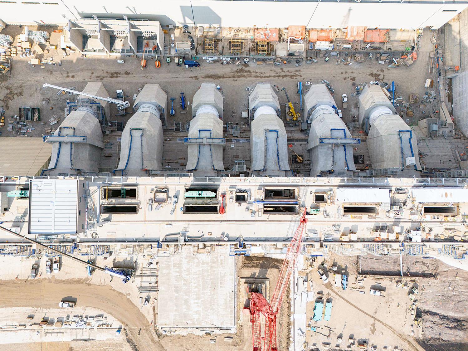 Blast walls house transformers that will transmit electricity generated in the powerhouse to transmission towers. These towers will sit above the penstocks.