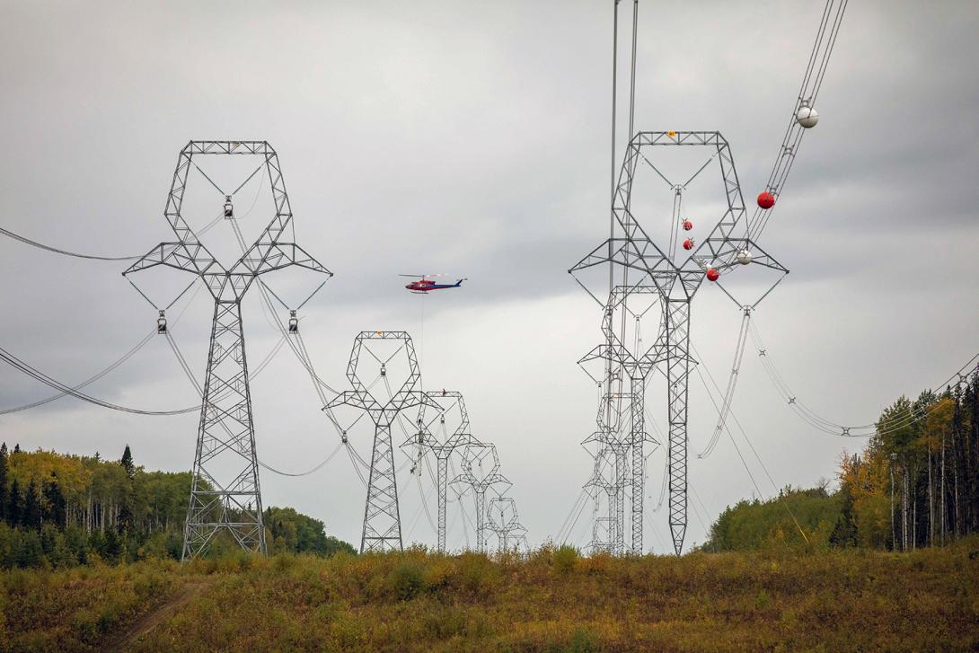 A helicopter delivers conductor spacers for the installation of the second Site C transmission line. | September 2021