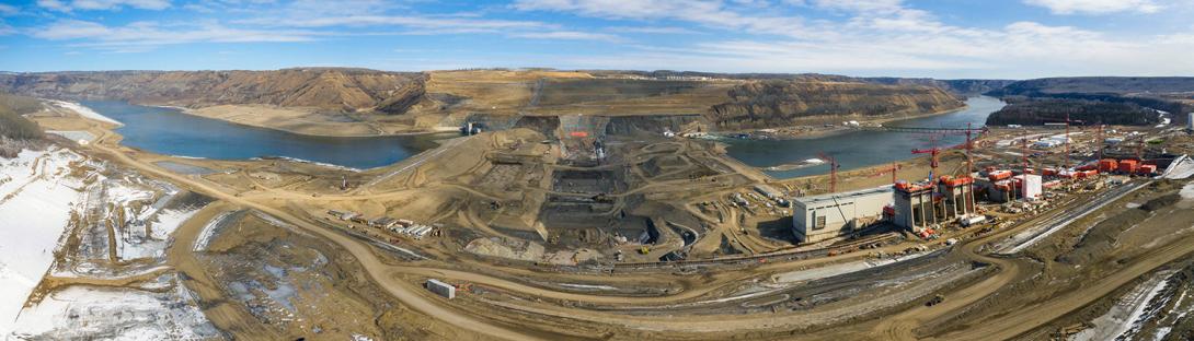 A panorama view of dam site excavations between the upstream and downstream cofferdams. Both cofferdams completely seal off the Peace River so that work on the earthfill dam can occur. | March 2021