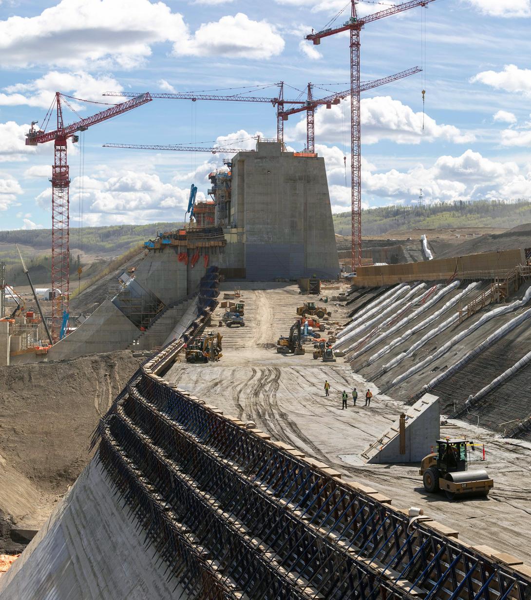 Crews place roller-compacted concrete on the dam and core buttress. | May 2021