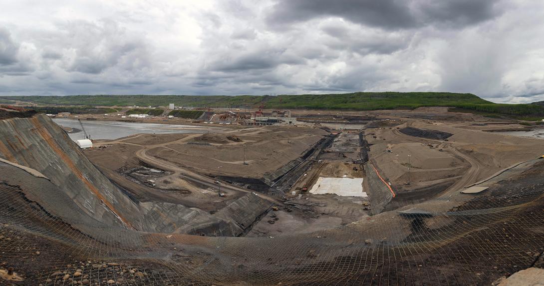 South-facing view of the dam core trench. The white tarps are covering stockpiled dam core till materials. | May 2021