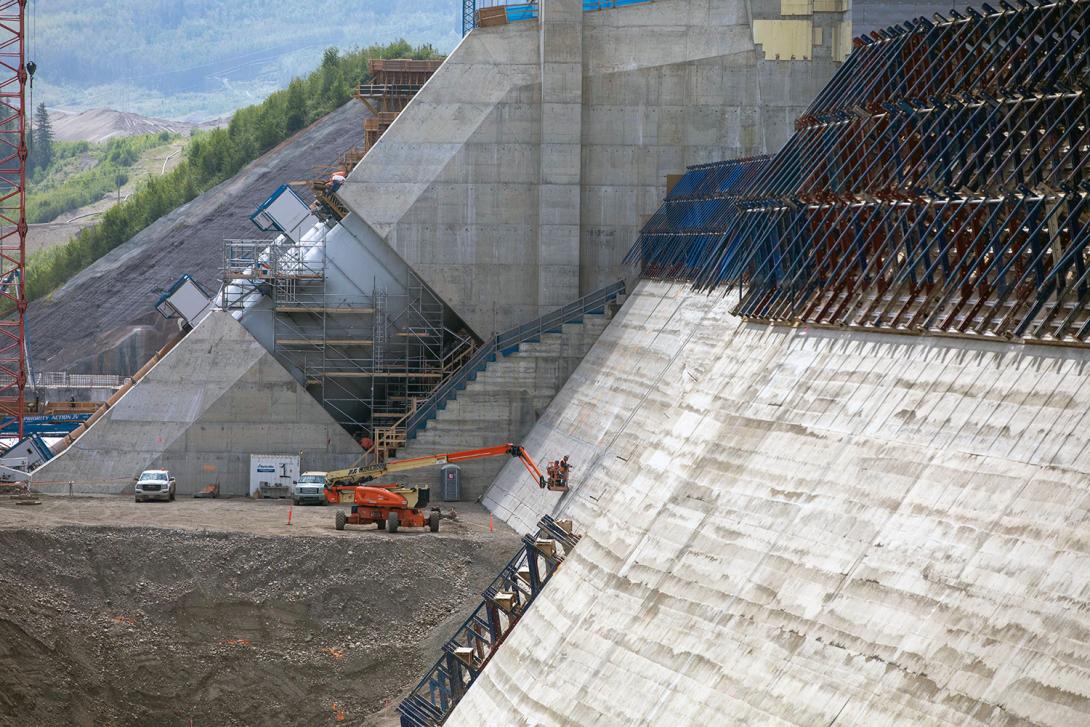 Workers inspect the roller-compacted concrete at the dam and core buttress after the formwork is removed. | June 2021
