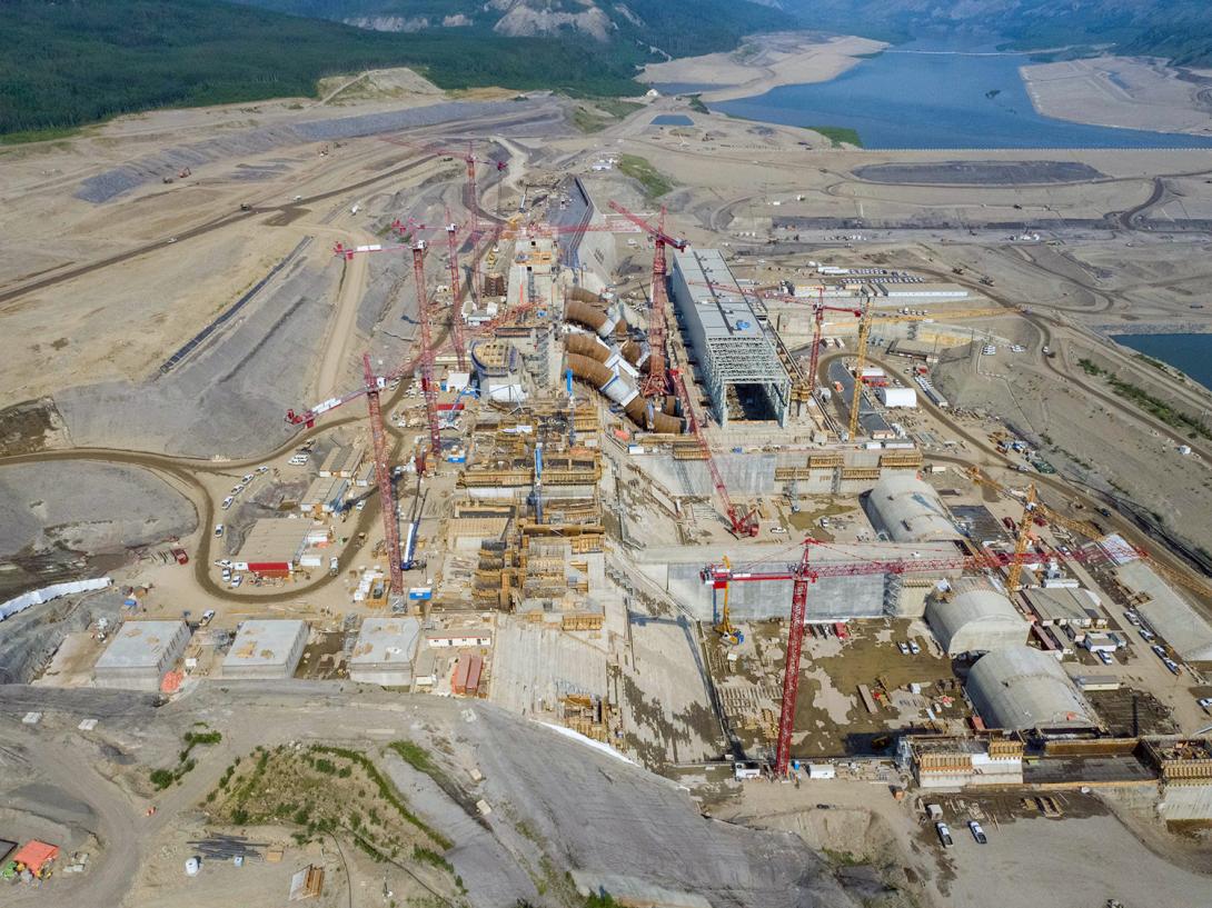 An upstream view of the approach channel at top left and the powerhouse, generating station, and spillways at centre. | June 2021