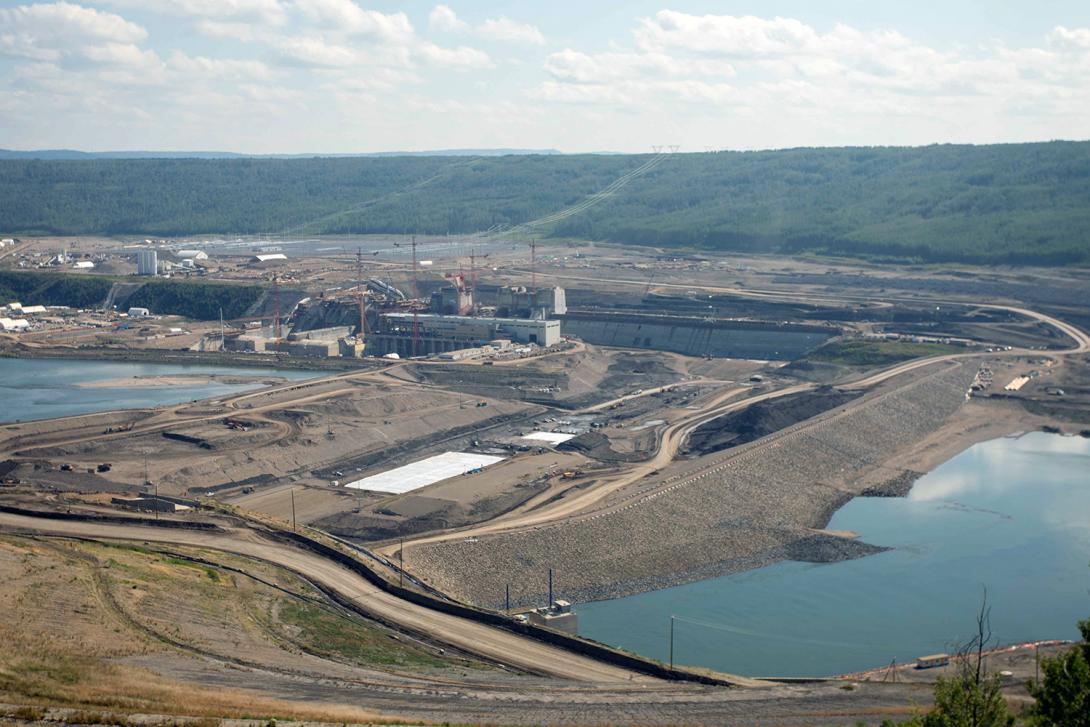 White tarpaulins are placed over freshly laid glacial till in the dam core trench to maintain moisture content. | July 2021