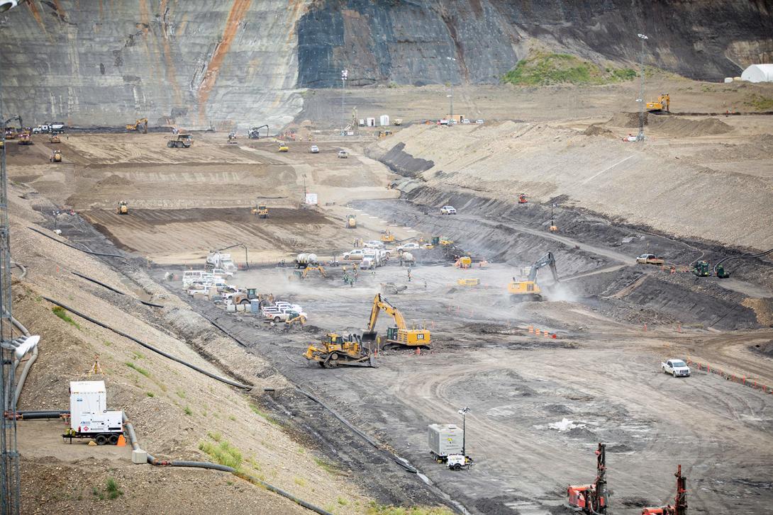 Crews prepare the left bank and remove of a top shale bedrock layer, to prepare for glacial till placement. | July 2021