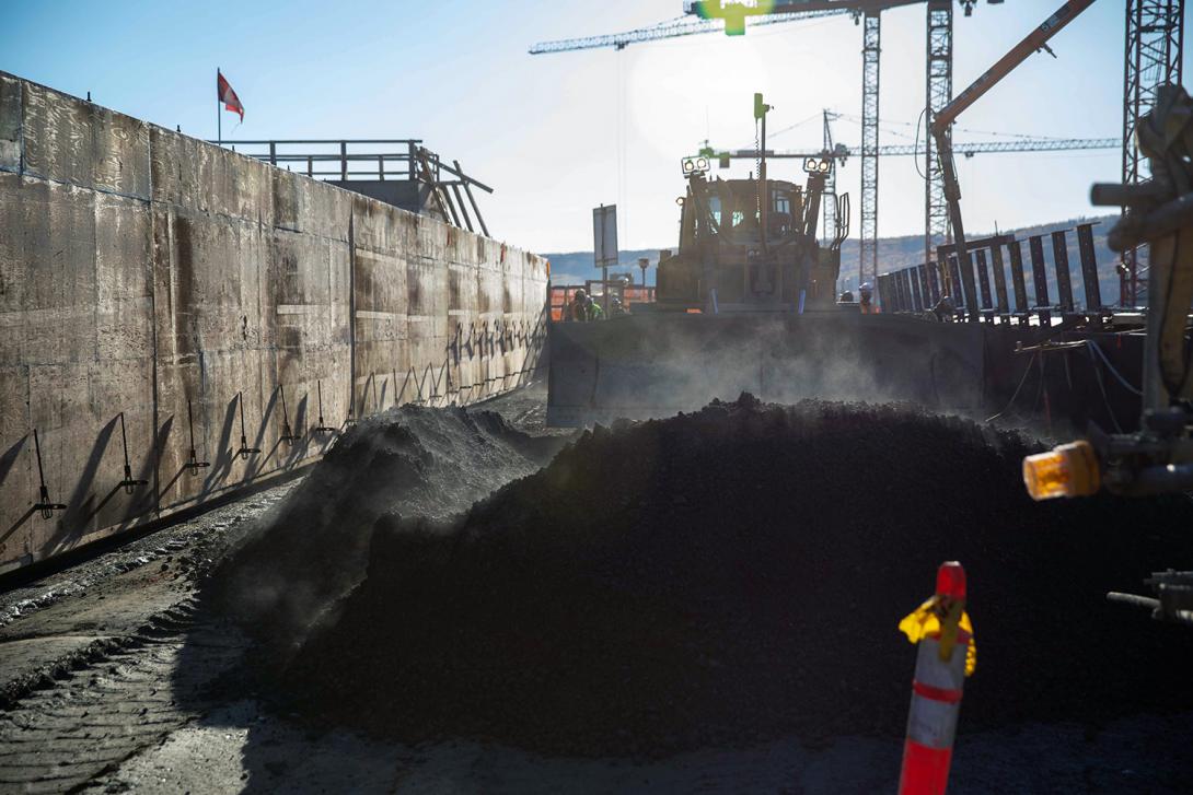 The second-to-last lift of roller-compacted concrete is spread on the dam and core buttress. | October 2021
