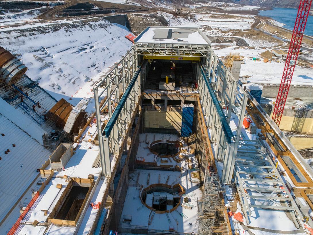 Construction continues on the structural steel building of the powerhouse over units 1 and 2.  The blue beams support the crane rails for the powerhouse bridge crane. | April 2020