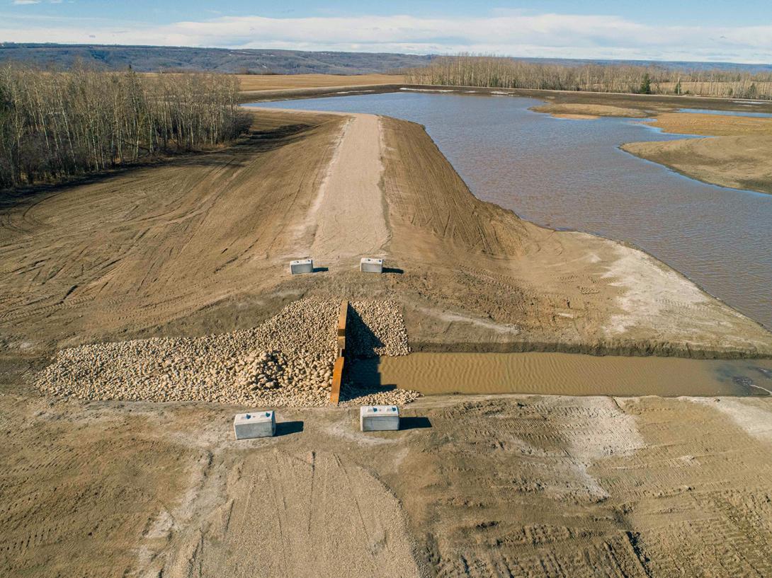 The earthen dam in the main basin in the restored Golata Creek wetlands allows control of the water level. | April 2020