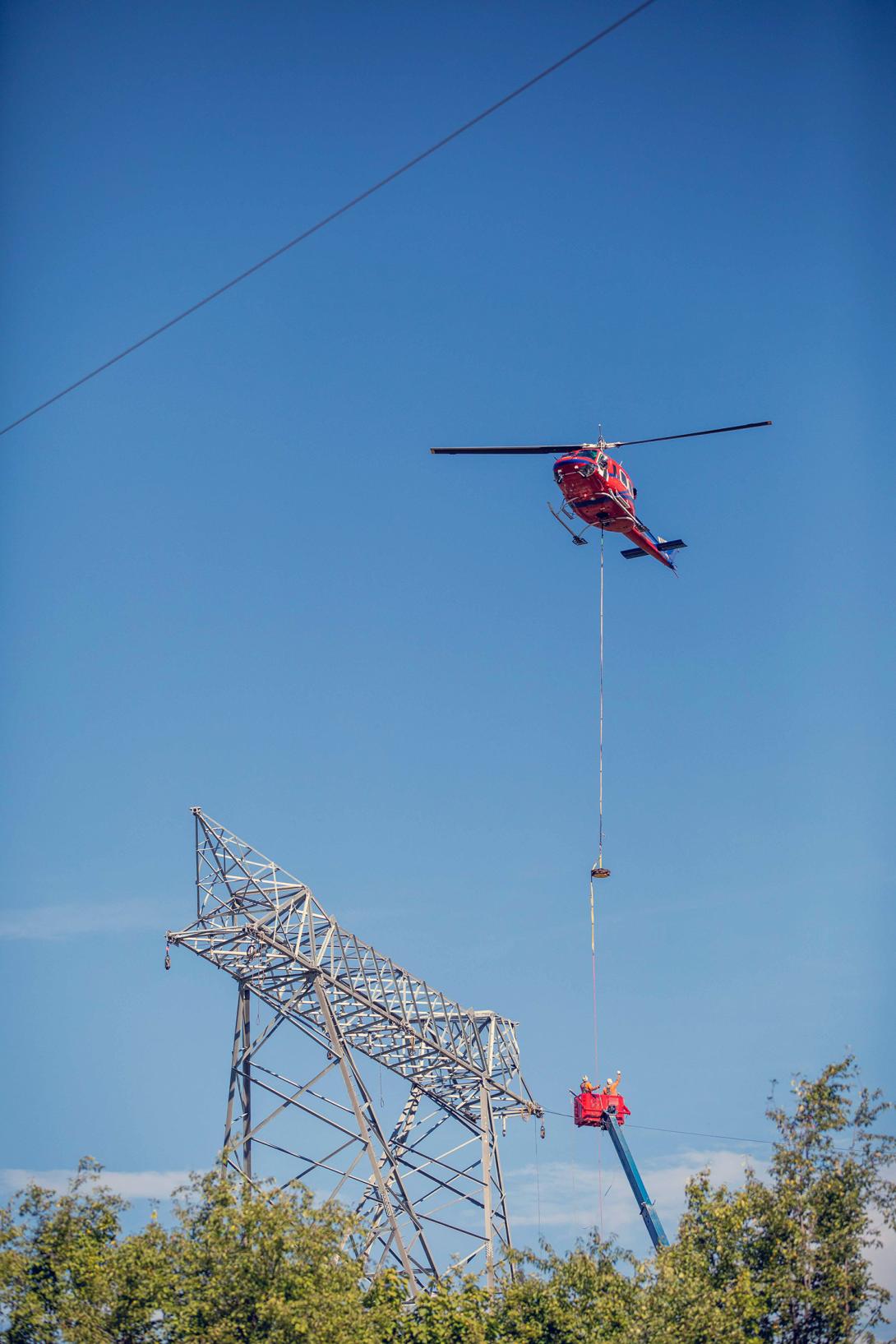 The helicopter completes the sock line installation on a free standing 500 kilovolt transmission tower near the Peace Canyon switchyard. | August 2020