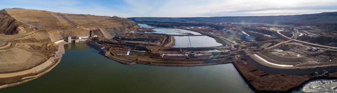 The completed upstream cofferdam diverts the Peace River around the main dam construction area through two tunnels in the river’s north bank. | October 2020