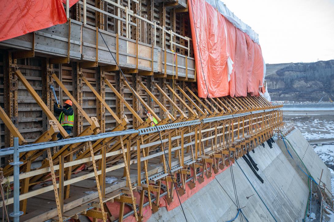 A worker tightens formwork with a 36-inch pipe wrench at the spillway wall. | December 2021