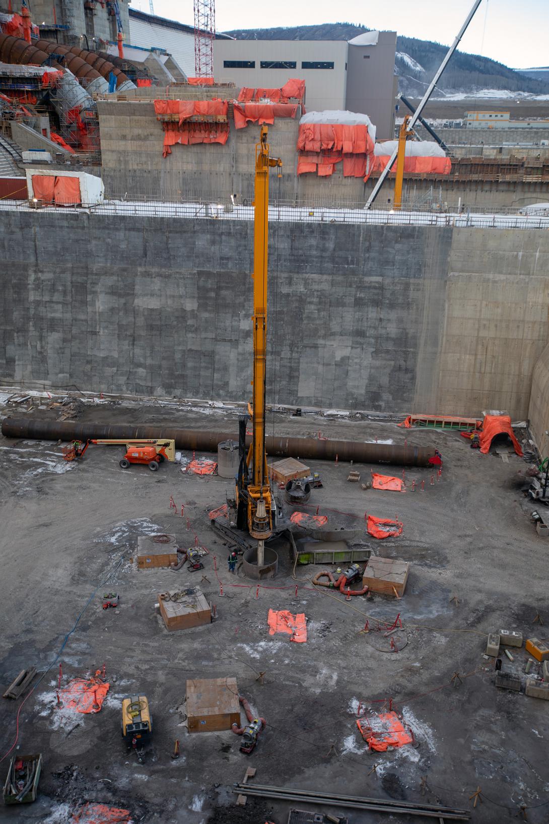 Crews drill a hole to enable placement of the last foundation enhancement pile in the east stilling basin. | December 2021