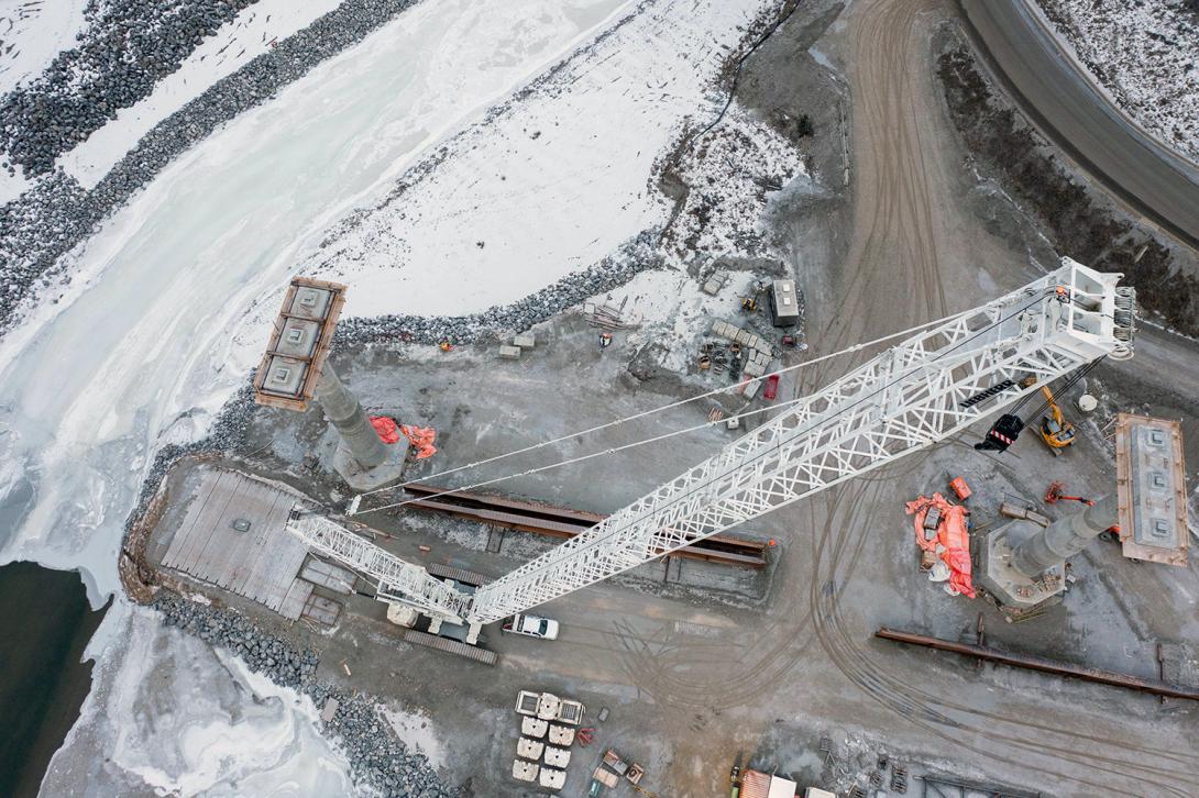 A crane at the Cache Creek bridge realignment construction site prepares to install girders. | December 2021 