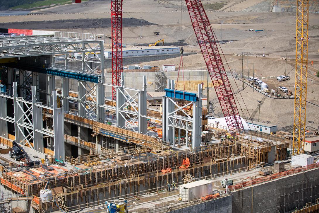 A bridge crane girder section is lowered into position at the auxiliary service bay of the powerhouse. | May 2021