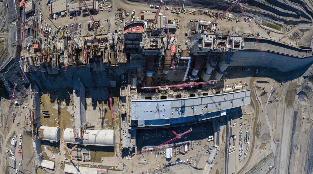 Aerial of the spillways, intakes and penstocks, roller compacted concrete dam and core buttress, the powerhouse and operations building. | September 2021