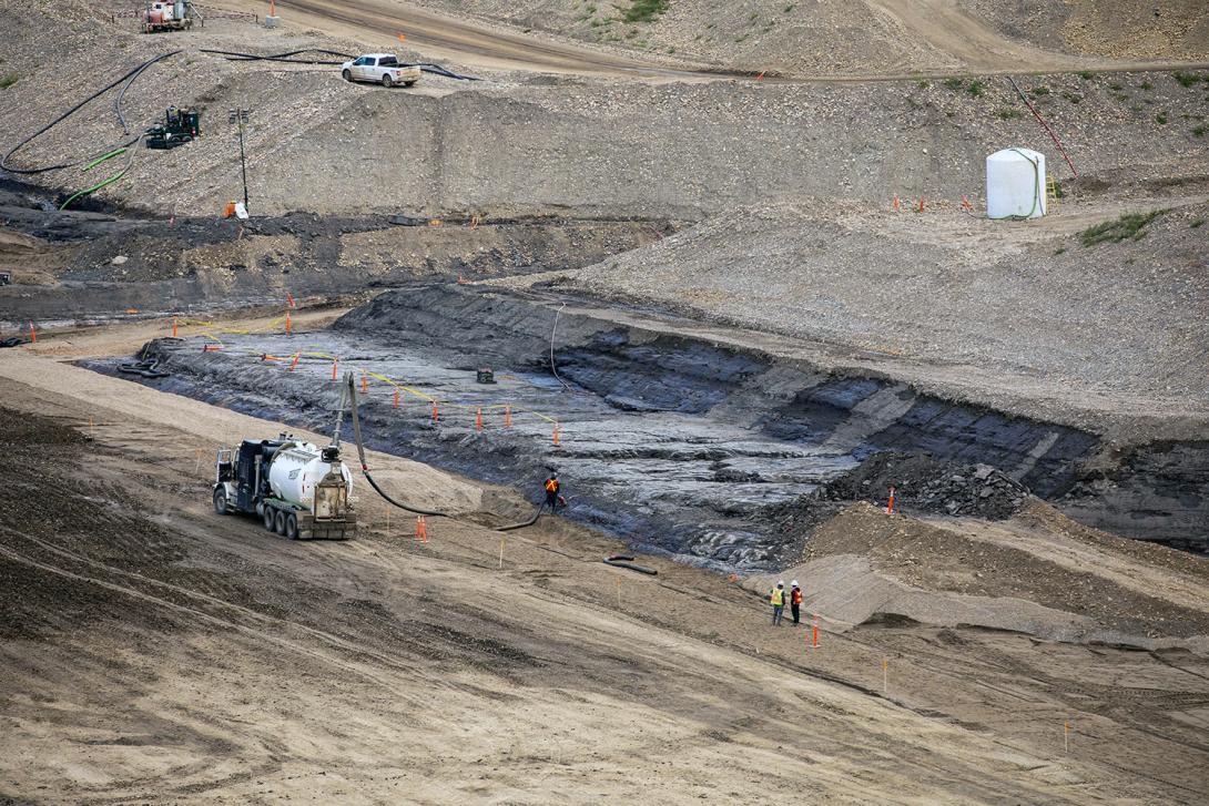 Crews clean the bedrock on the downstream side of the dam core trench. | September 2021