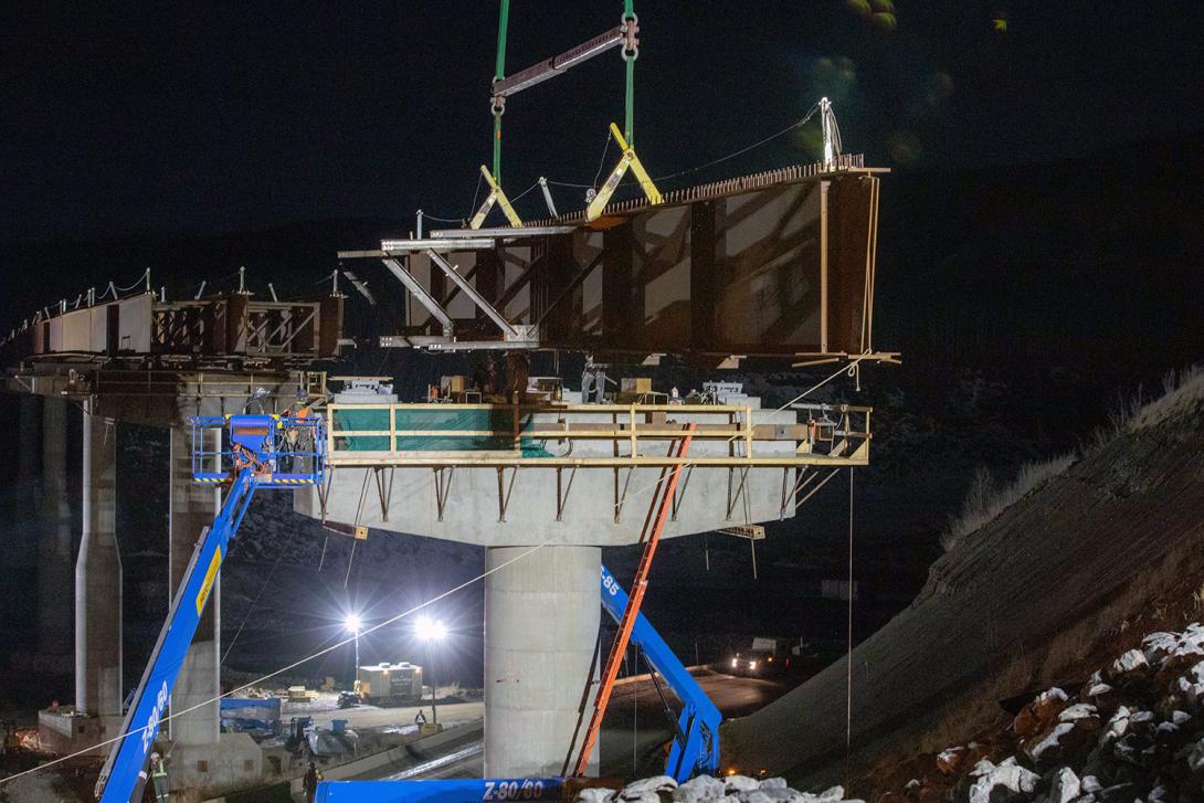 The first girder is moved into place for the Farrell Creek Bridge, as crews prepare for the installation of the adjacent girder and cross-bracing. | March 2022