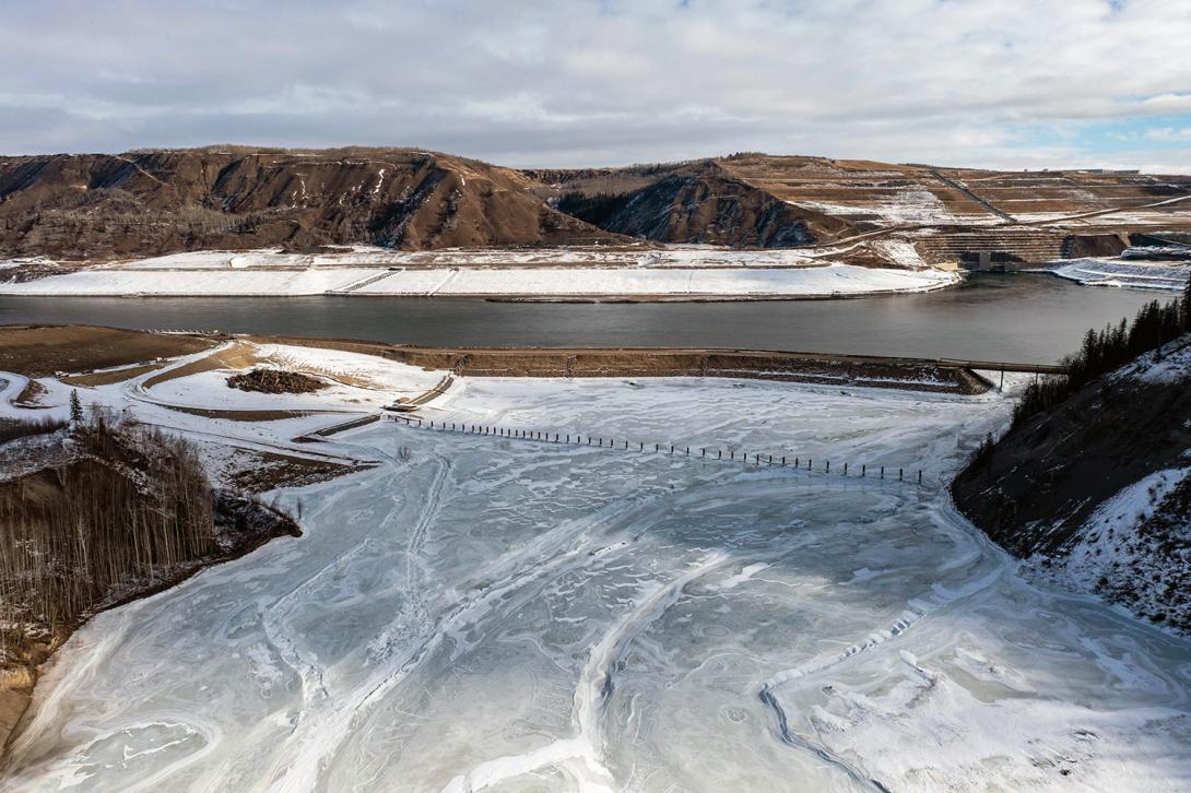 Where the Moberly and Peace rivers meet upstream of the dam, the debris boom can be seen, along with the inlet portal where the river flows around the dam. | March 2023