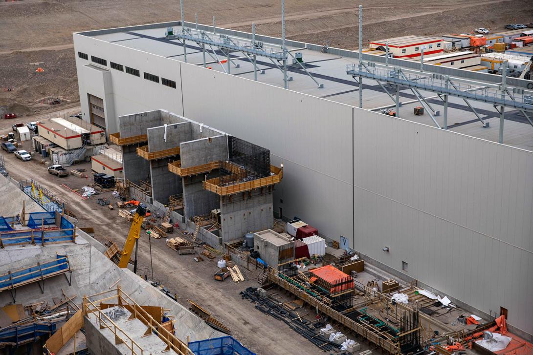 Concrete blast walls are built behind the powerhouse to enclose the three transformers. | April 2023