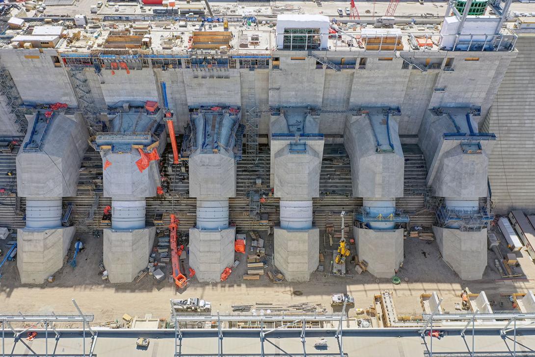 The flexible couplings are the narrower portion in the middle of each penstock. They allow the top of the penstock (embedded into the inlet) to move independently of the bottom of the penstock (embedded into the powerhouse). | May 2023