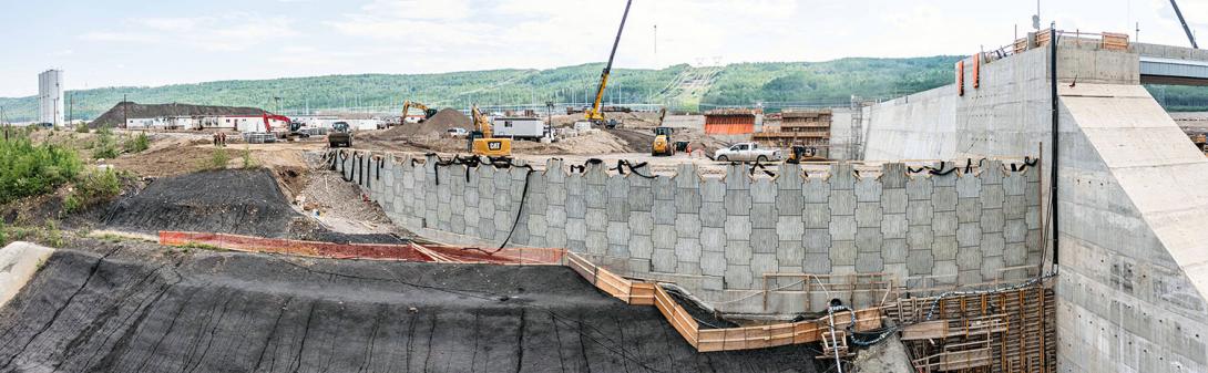 A mechanically-stabilized earth wall is being built on the east end of the auxiliary spillway. | May 2023