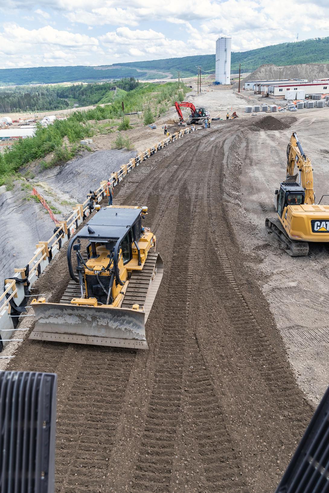 Aggregate is placed and compacted against the precast panels of the mechanical stabilized earth wall on the east side of the auxiliary spillway. | May 2023