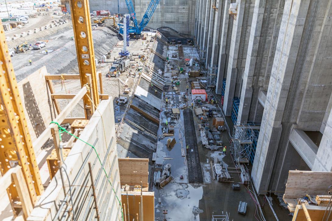 East-facing view of the foundation enhancement at the tailrace.  The last section of the pile cap is being prepped for  concrete placement.  Crews are working on the reinforcing steel for the rock trap in front of the tailrace gates. | May 2023