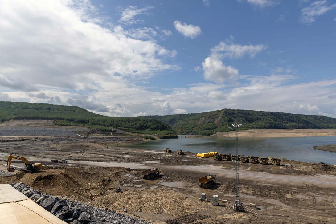 Finishing work is underway on the upstream side of the dam. Yellow anchors for the permanent debris management boom are at centre. | August 2023