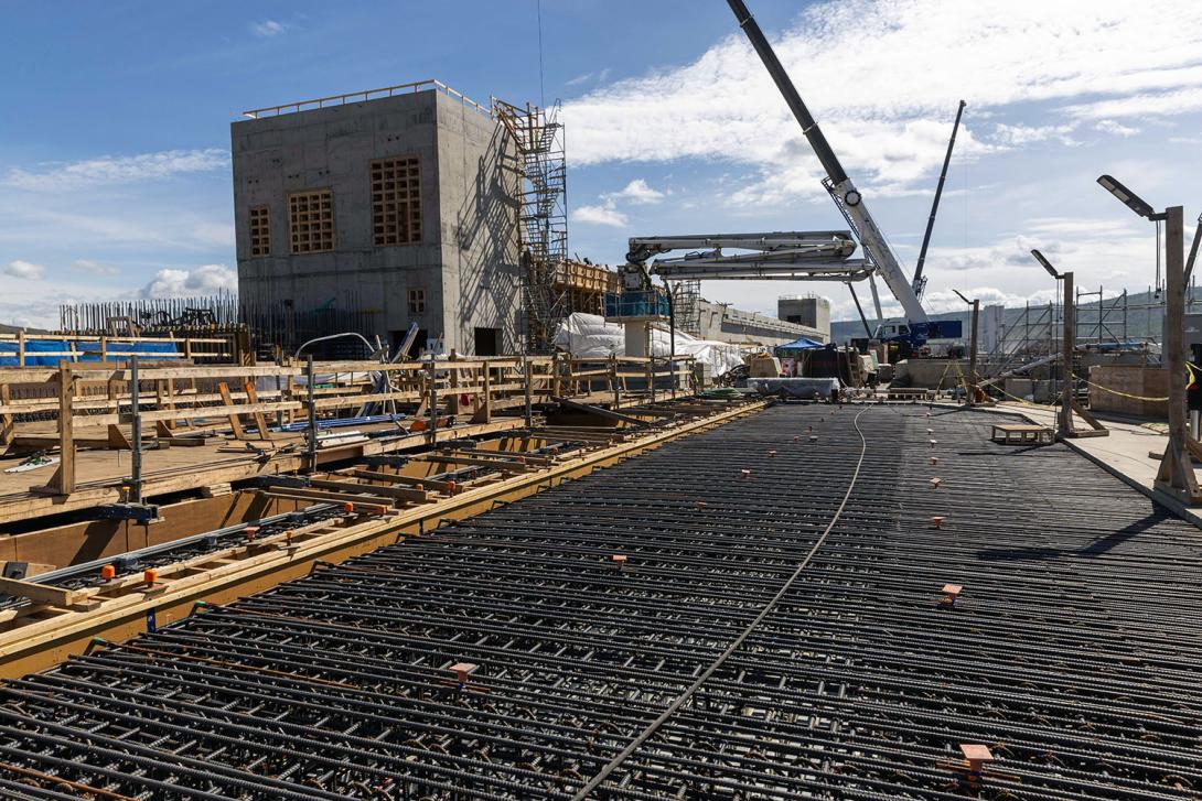 Reinforcing steel is placed ahead of a concrete pour in the transition block separating the spillways from the penstocks. | August 2023
