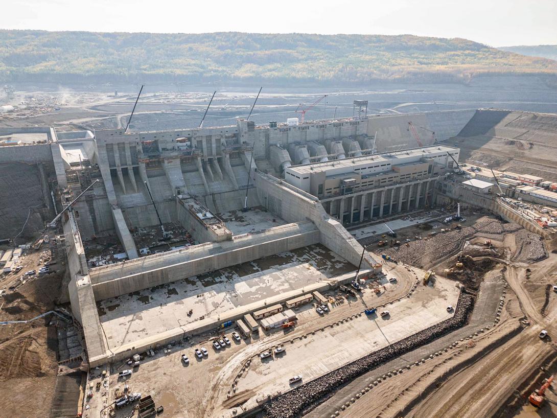 Water will go through six penstocks into the powerhouse, then exit through the tailrace. The spillways on the left will safely pass flows from the reservoir.