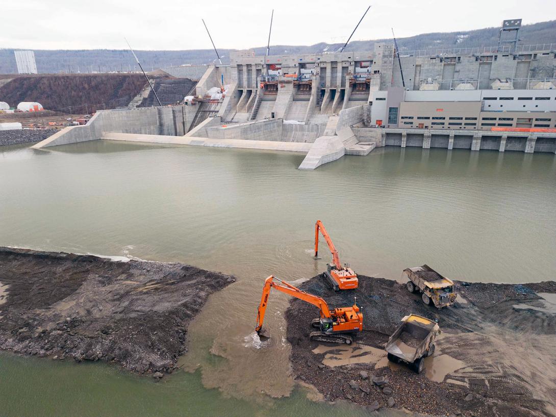 The right bank cofferdam was in place to create a safe, dry area during construction of the buttress, powerhouse, and spillway structures. It was breached in late October and will be removed before the dam starts generating electricity. | November 2023