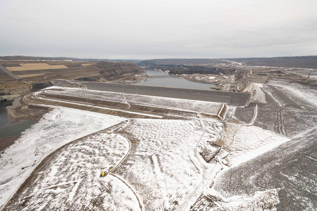 Downstream at the dam, the Peace River passes through the diversion inlet portal at left. When the dam is in operation the reservoir will flow right into the approach channel, through the intakes and down the penstocks into the turbine units. 