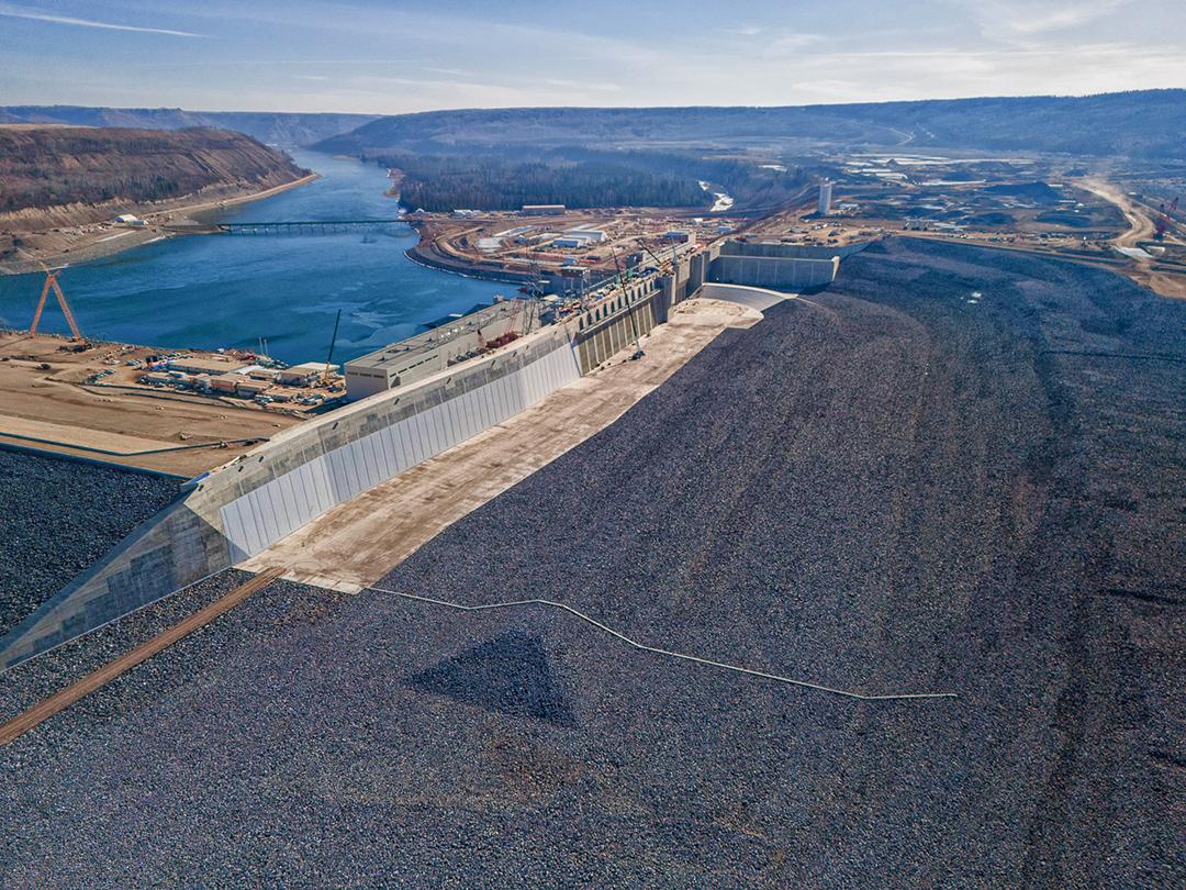 The completed approach channel flows around the completed dam to deliver water to the intakes. | March 2024