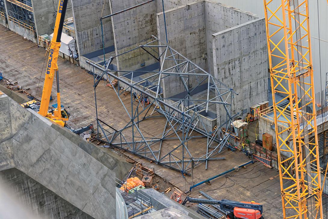 Two-cranes will shift a transmission tower section from the horizontal to vertical position to lift for installation. 