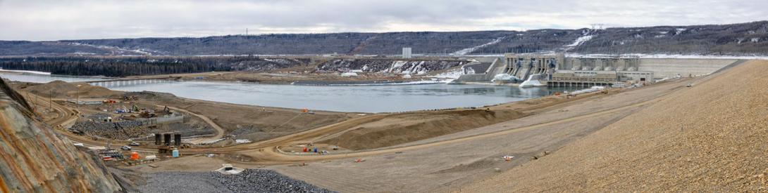 Overlooking the north abutment drainage channel and diversion tunnel outlet with the tailrace, spillways and generating station in the background. | April 2025
