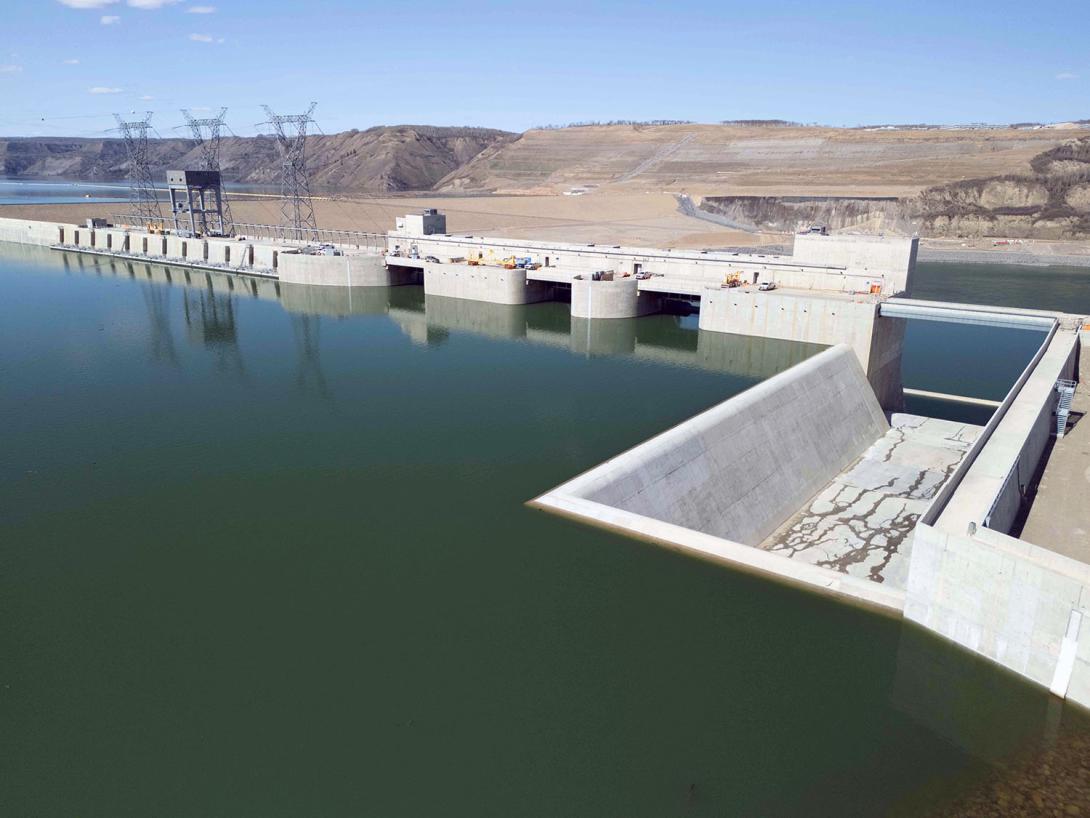 The upstream side of the roller compacted concrete buttress at the approach channel. From left, the intakes, main spillways, with an overflow spillway at far right. | April 2025